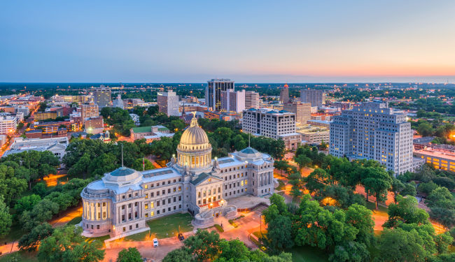 Aerial view of historic buildings and trees at dusk.