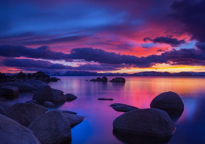 Water and rocks with a sunset in the background.